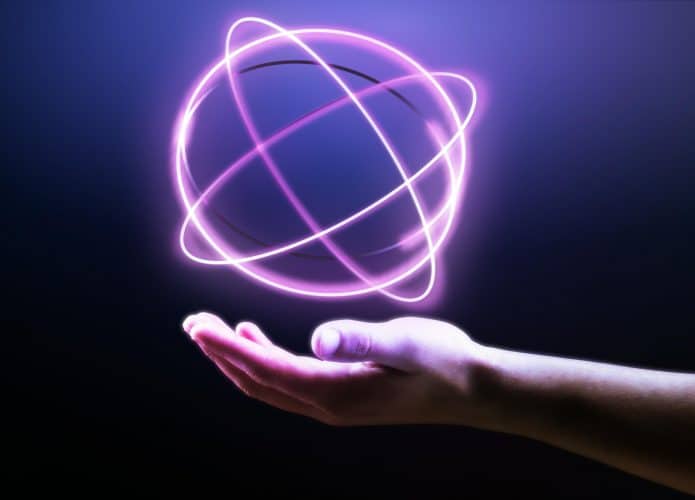 mão de uma pessoa mostrando um holograma de átomo