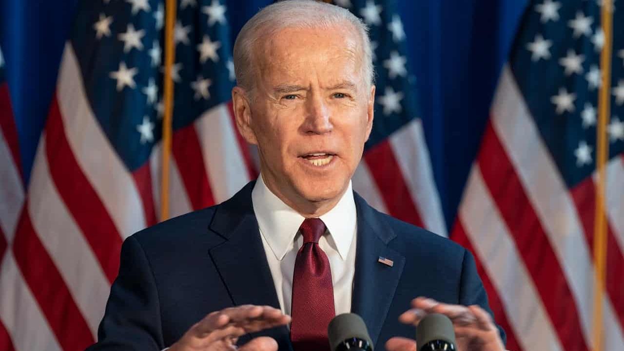 Joe Biden enquanto presidente dos Estados Unidos durante discurso em palanque em frente bandeiras do país