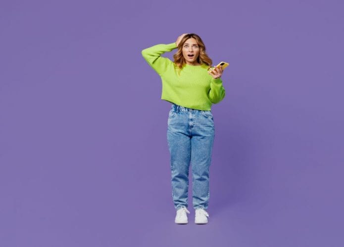 mulher com mão na cabeça e celular na mão