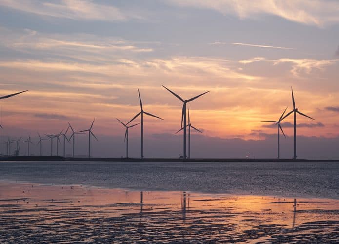 Turbinas de energia eólica offshore durante pôr do sol