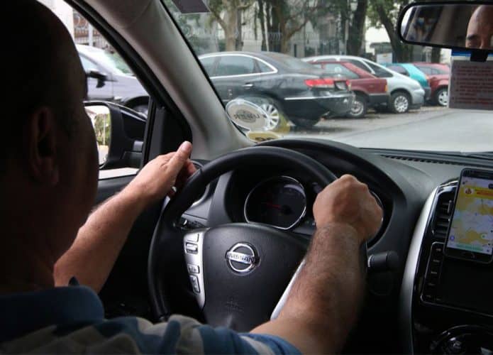 Motorista em carro prestando serviço para a Uber