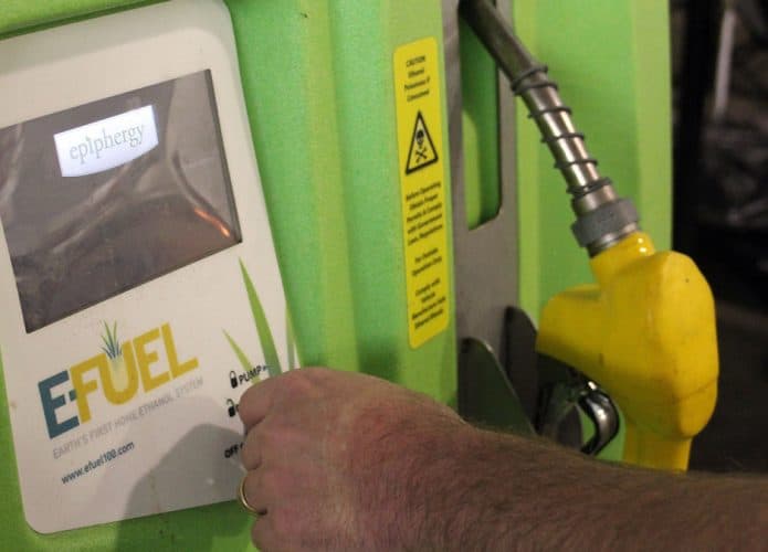 Homem com mão perto de bomba de combustível sem petróleo, o e-fuel