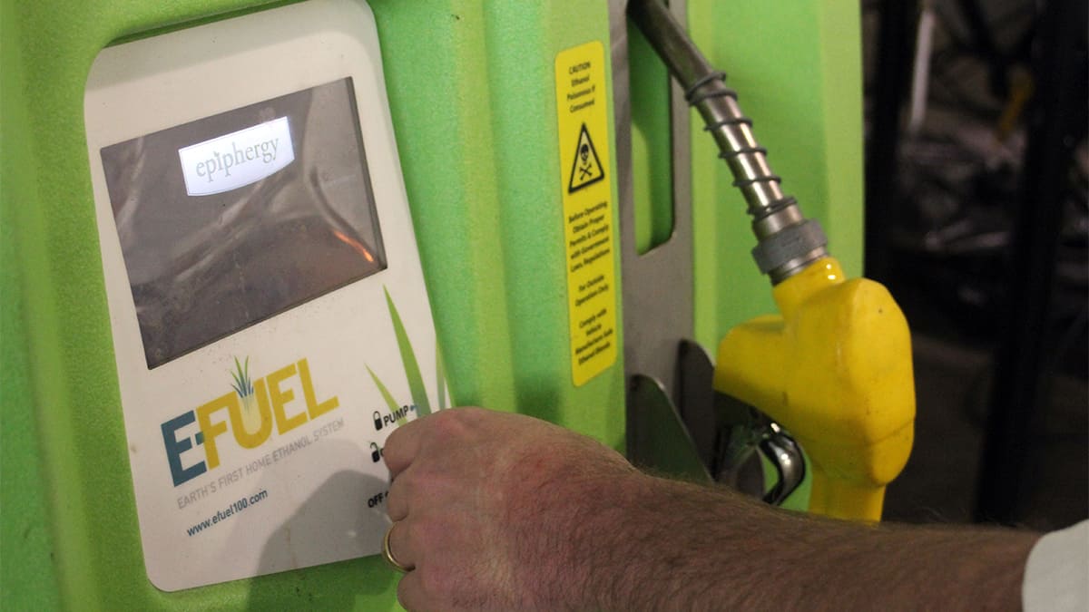 Homem com mão perto de bomba de combustível sem petróleo, o e-fuel