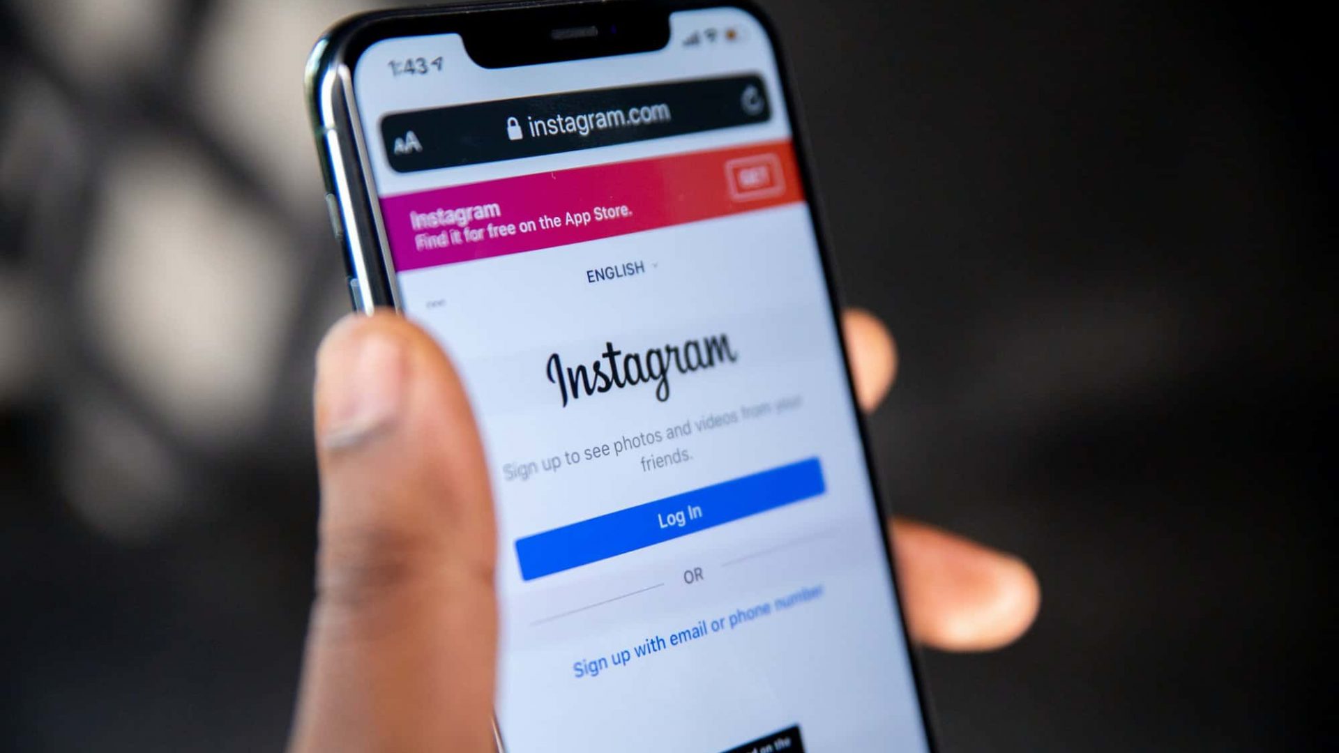 Pessoa segurando iPhone com tela de login do Instagram aberta