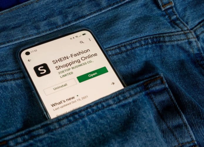 Bolso com celular e imagem na tela do app da Shein