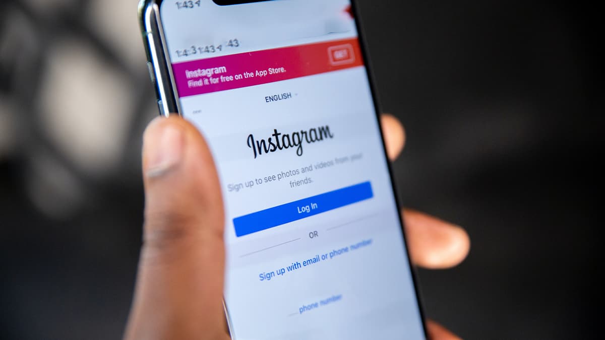Pessoa segurando celular com tela de login do Instagram aberta