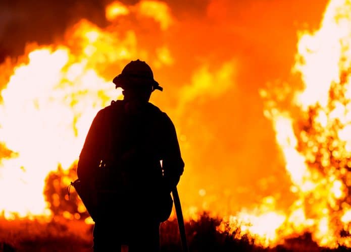 Silhueta de bombeiro encarando incêndio na Califórnia
