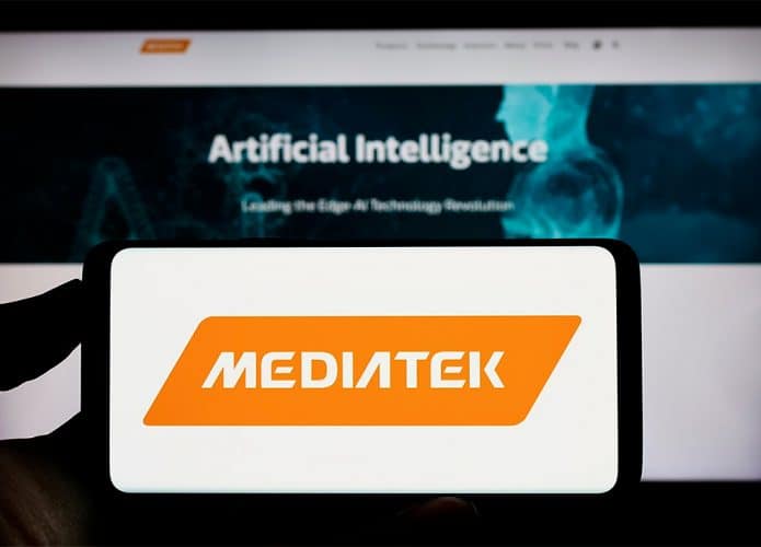 Celular com logotipo da MediaTek na tela colocado em frente tela de computador com página sobre IA aberta