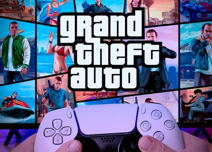 Pessoa segurando controle de PlayStation 5 em frente TV com imagem do GTA aberta