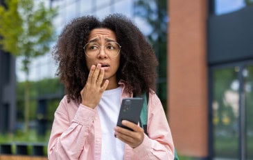 Mulher preocupada com o celular na mão
