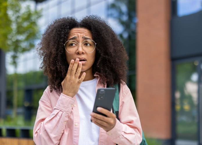 Mulher preocupada com o celular na mão