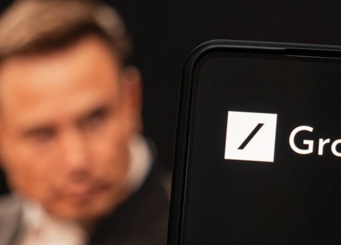Ao fundo, imagem borrada de Elon Musk; à frente, logo do Grok em um smartphone