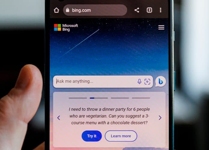 Pessoa segurando celular com Bing aberto