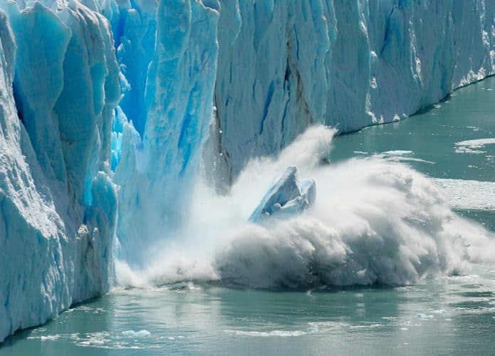 Pedaço de geleira despencando no mar por conta das mudanças climáticas