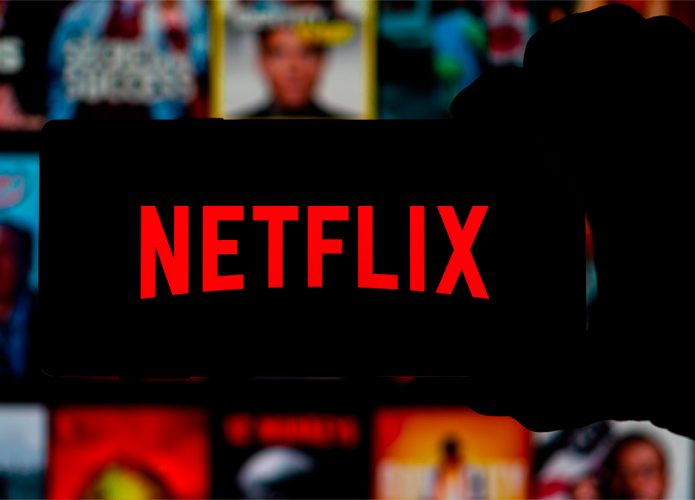 Pessoa segurando celular com logotipo da Netflix