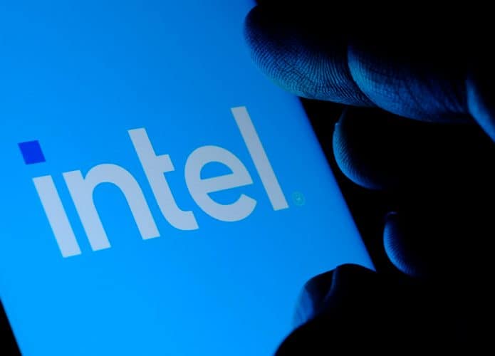Pessoa tocando em tela de celular com logotipo da Intel na tela