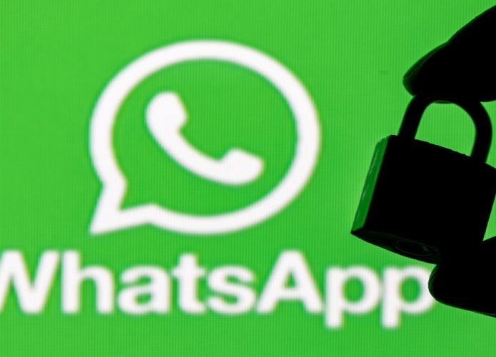 Imagem de símbolo do WhatsApp e sombra de uma mão com cadeado