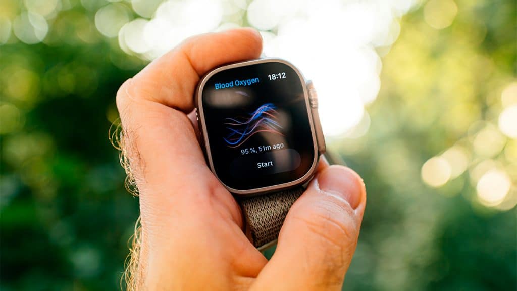 Homem segurando Apple Watch exibindo medição de oxigenação no sangue