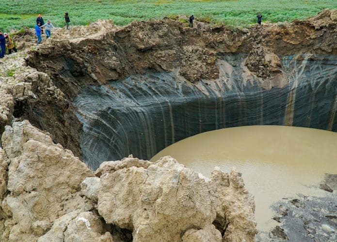 Pessoas na beira de uma das crateras na Sibéria
