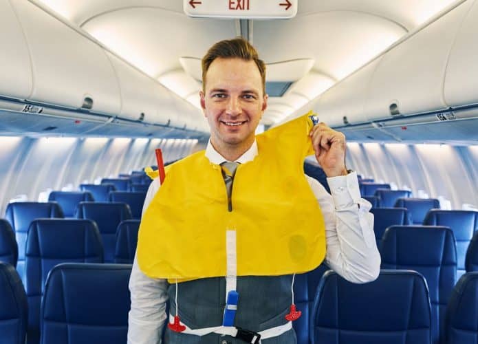 Comissário de bordo em instruções em avião
