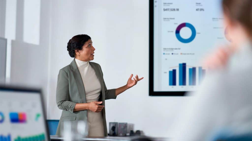 Mulher apresentando slide após usar Microsoft Copilot for Finance