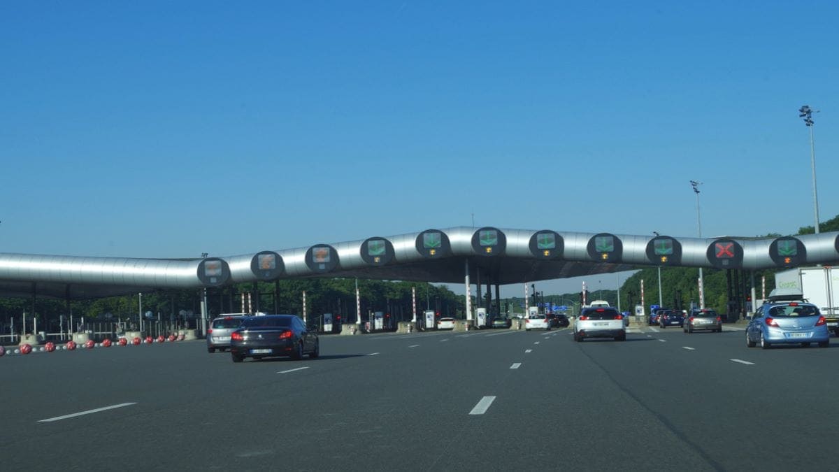 Imagem de carros chegando em um pedágio de rodovia