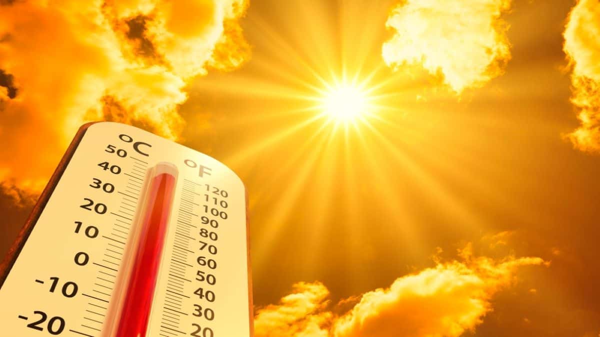 Termômetro gigante de temperatura com sol escaldante no fundo