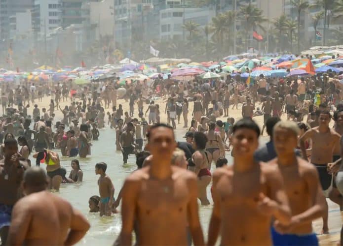 Pessoas em praia no Rio de Janeiro durante dia quente