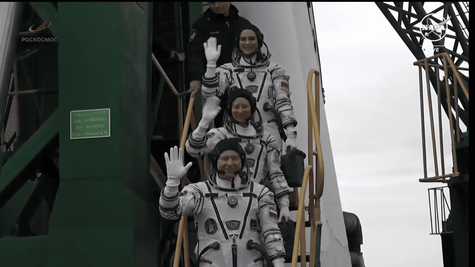 Tripulação do fogeute Soyus se despendindo antes de entrarem no veiculo e a missão ser abortada. De baixo para cima são Oleg Novitskiy, Tracey Caldwell Dyson e Marina Vasilevskaya (Crédito: NASA TV)