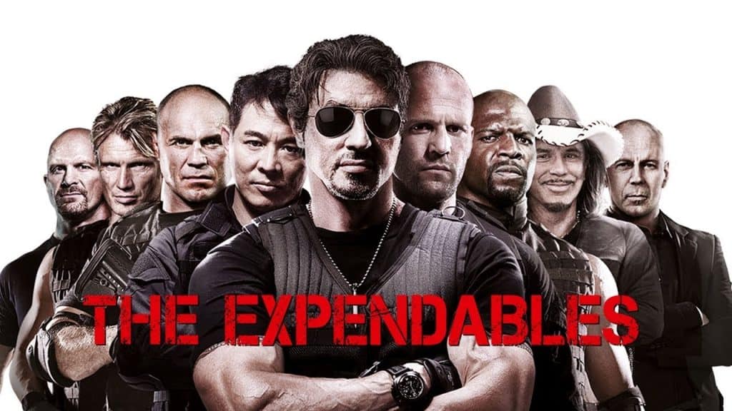 imagem mostra os principais personagens do filme enfileirados atrás do personagem principal com um fundo branco