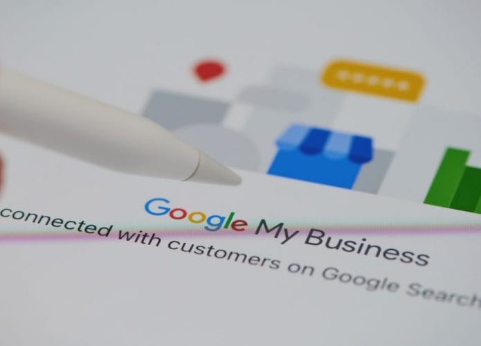 caneta apontando para papel com logo e ícone do Google Meu Negócio