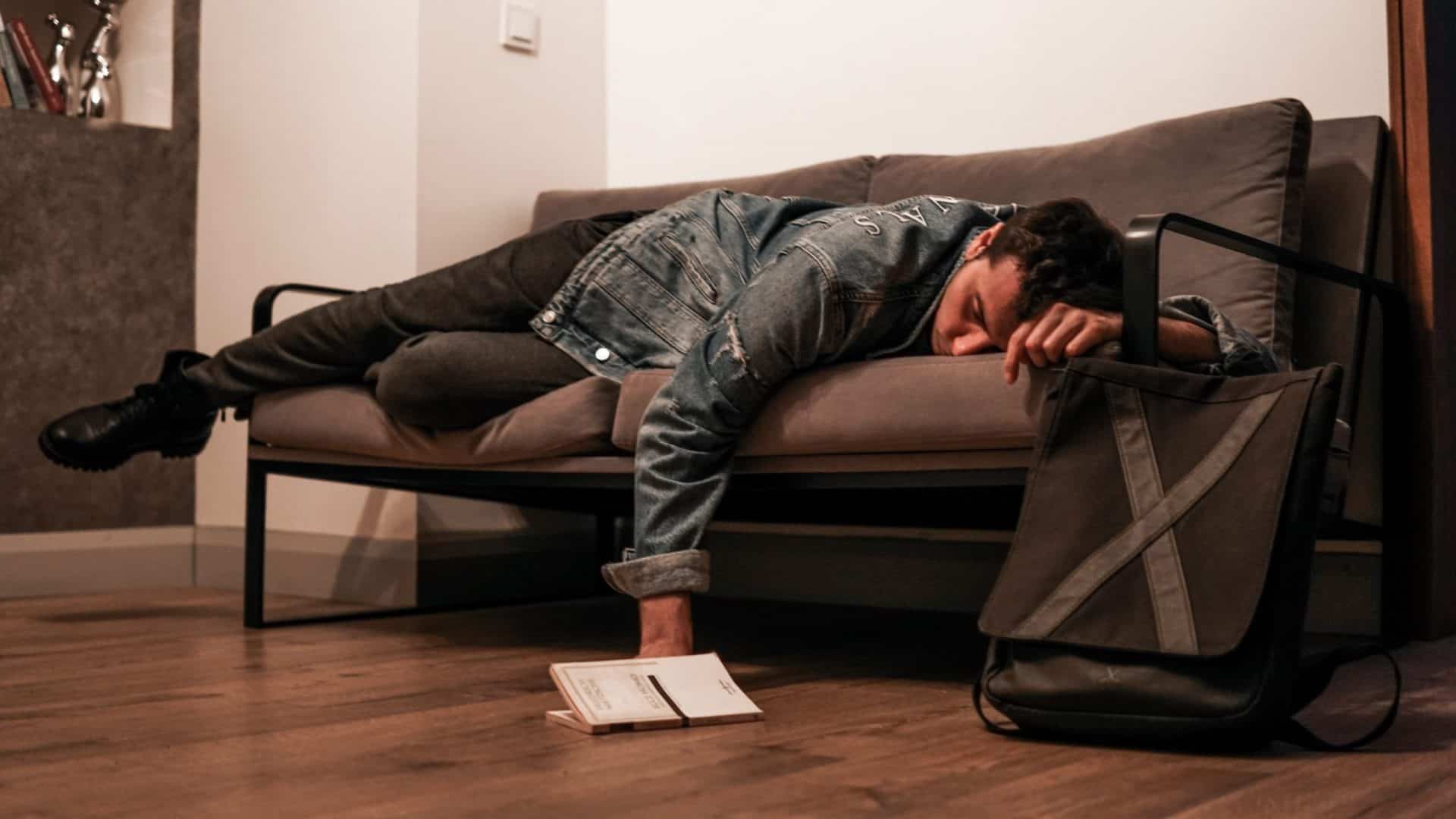 Homem dormindo em sofá, saiba monitorar e melhorar qualidade do sono