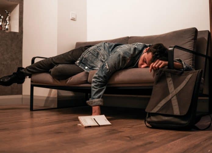 Homem dormindo em sofá, saiba monitorar e melhorar qualidade do sono