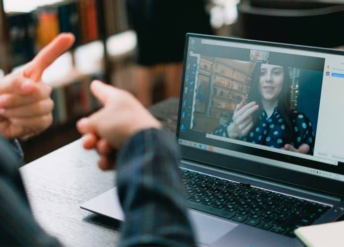 Pessoa usando tradutor de Libras com inteligência artificial apresentado pela Lenovo em notebook da empresa