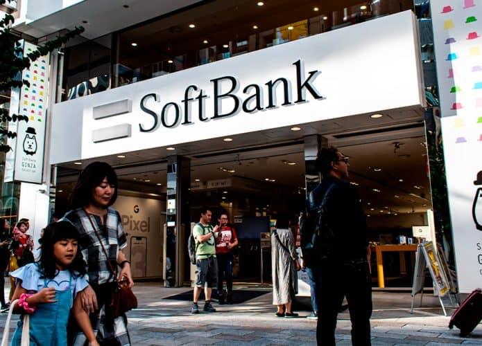 Pessoas andando na frente da fachada do SoftBank no Japão