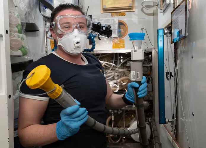 A astronauta da NASA Serena Auñón-Chancellor com a mangueira a vácuo usada para fazer xixi (Crédito: NASA/Flickr ( CC BY-NC-ND 2.0 )