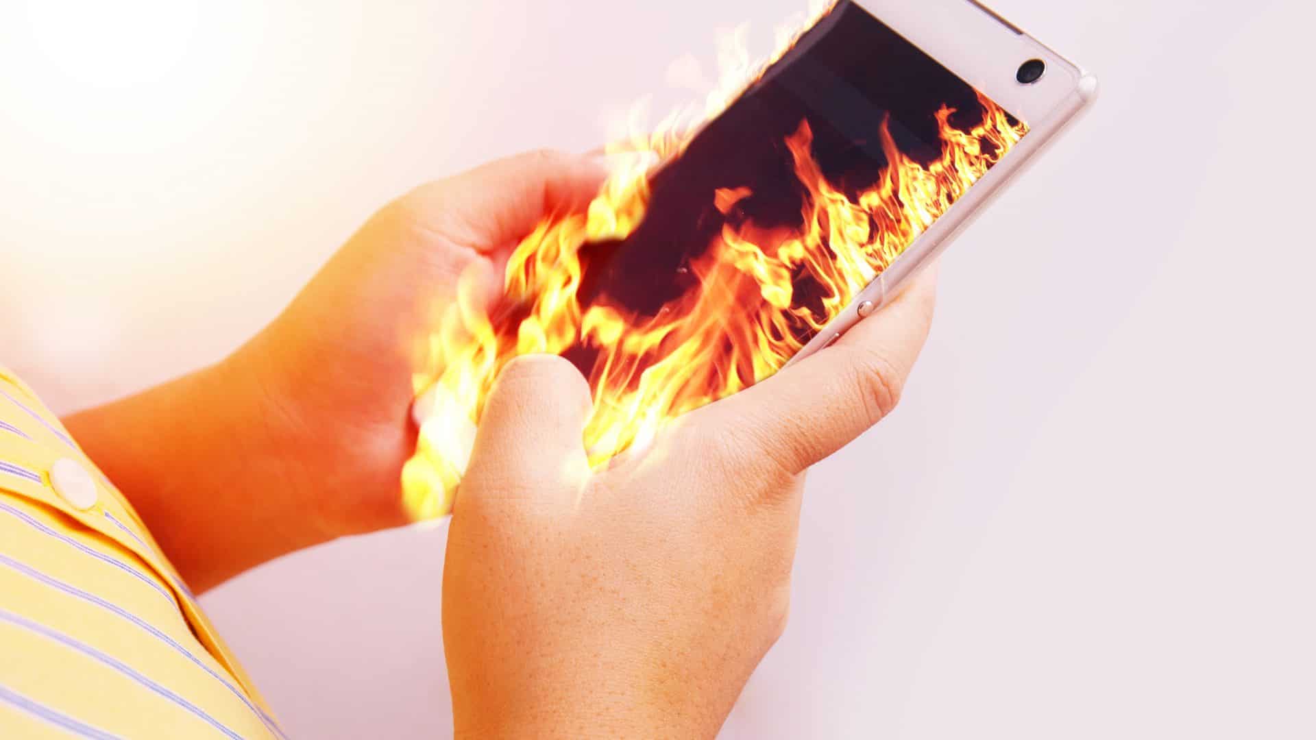 Imagem mostra pessoa segurando celular pegando fogo