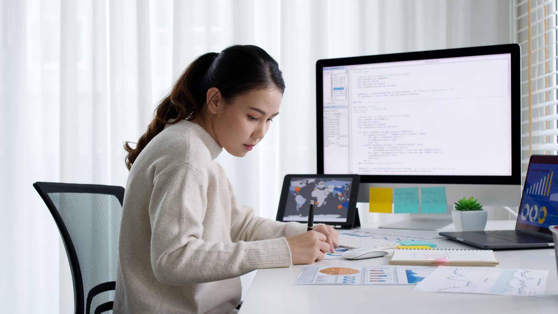 Imagem mostra mulher estudando com computador para cursos de IA para iniciantes