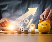 Homem colocando moedas em um cofre no formato de porquinho