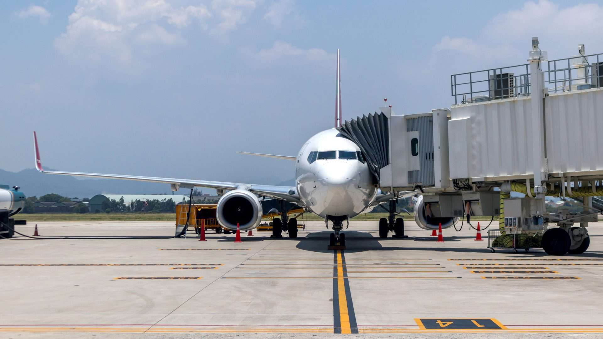 Avião em aeroporto com braço acoplado à sua porta
