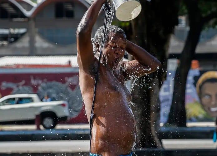 Homem jogando água sobre si mesmo em dia quente no Rio de Janeiro