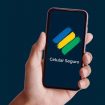 Montagem de pessoa segurando celular com logotipo do aplicativo Celular Seguro na tela
