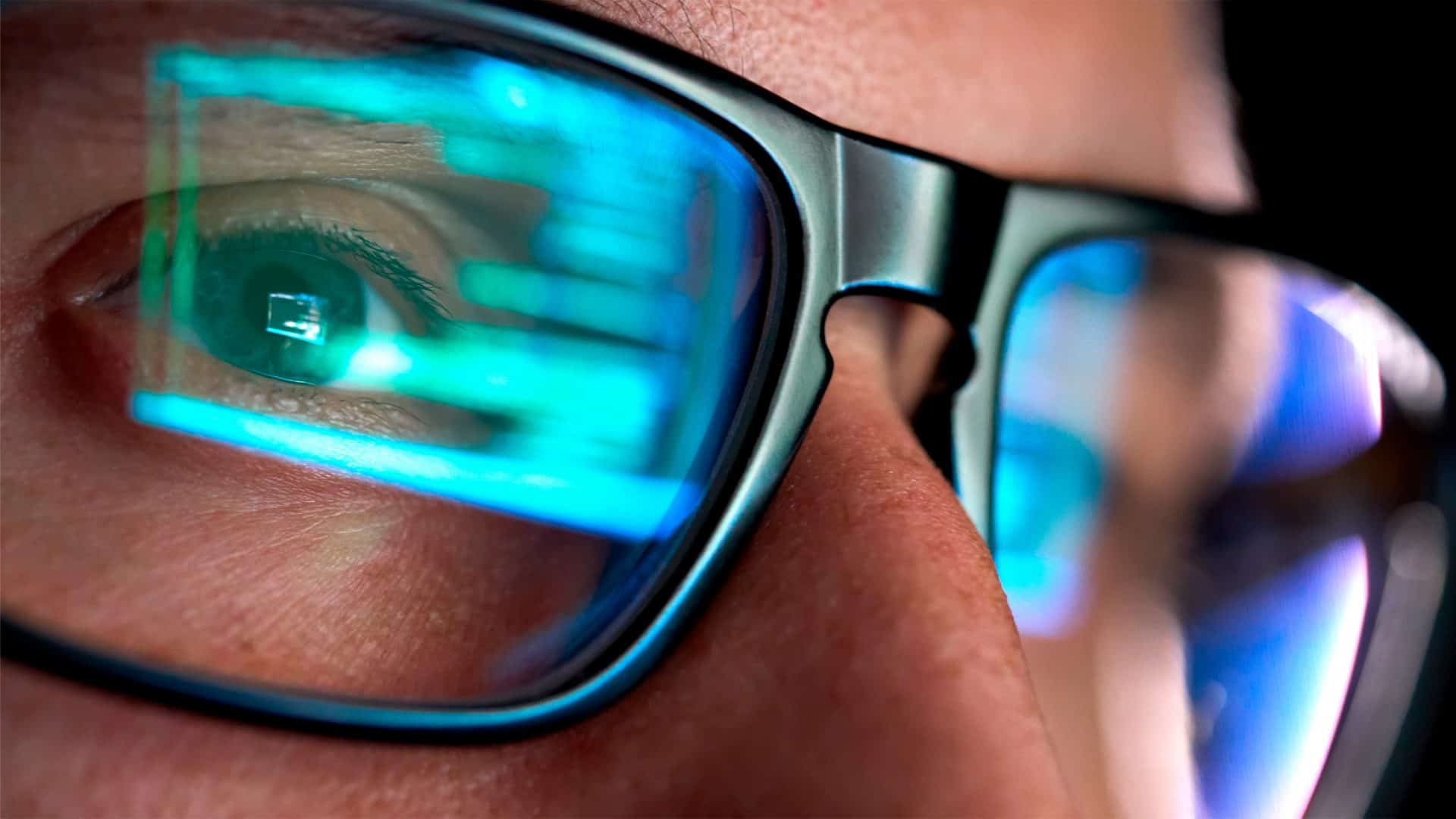 Close em óculos de pessoa olhando para tela de computador