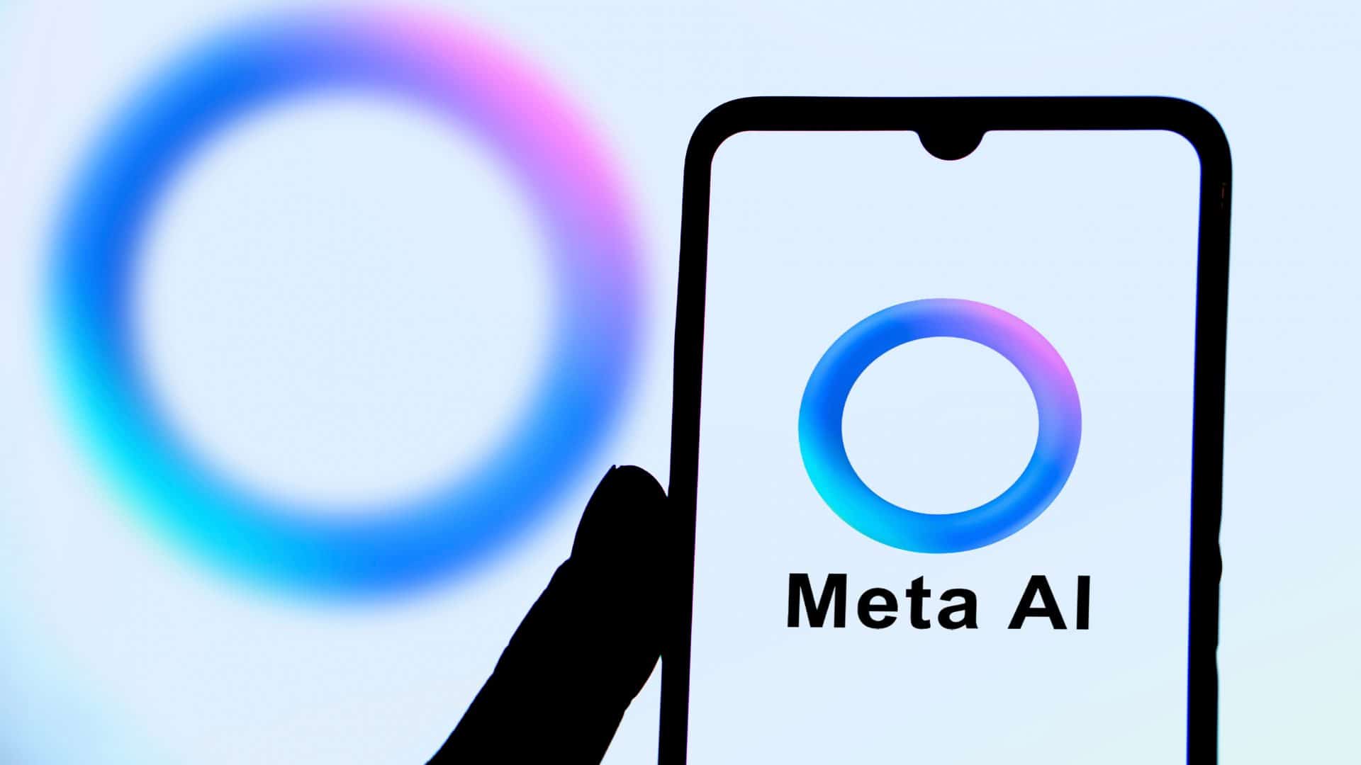 Pessoa segurando celular com logotipo da IA da Meta na tela; ao fundo, também aparece o logotipo