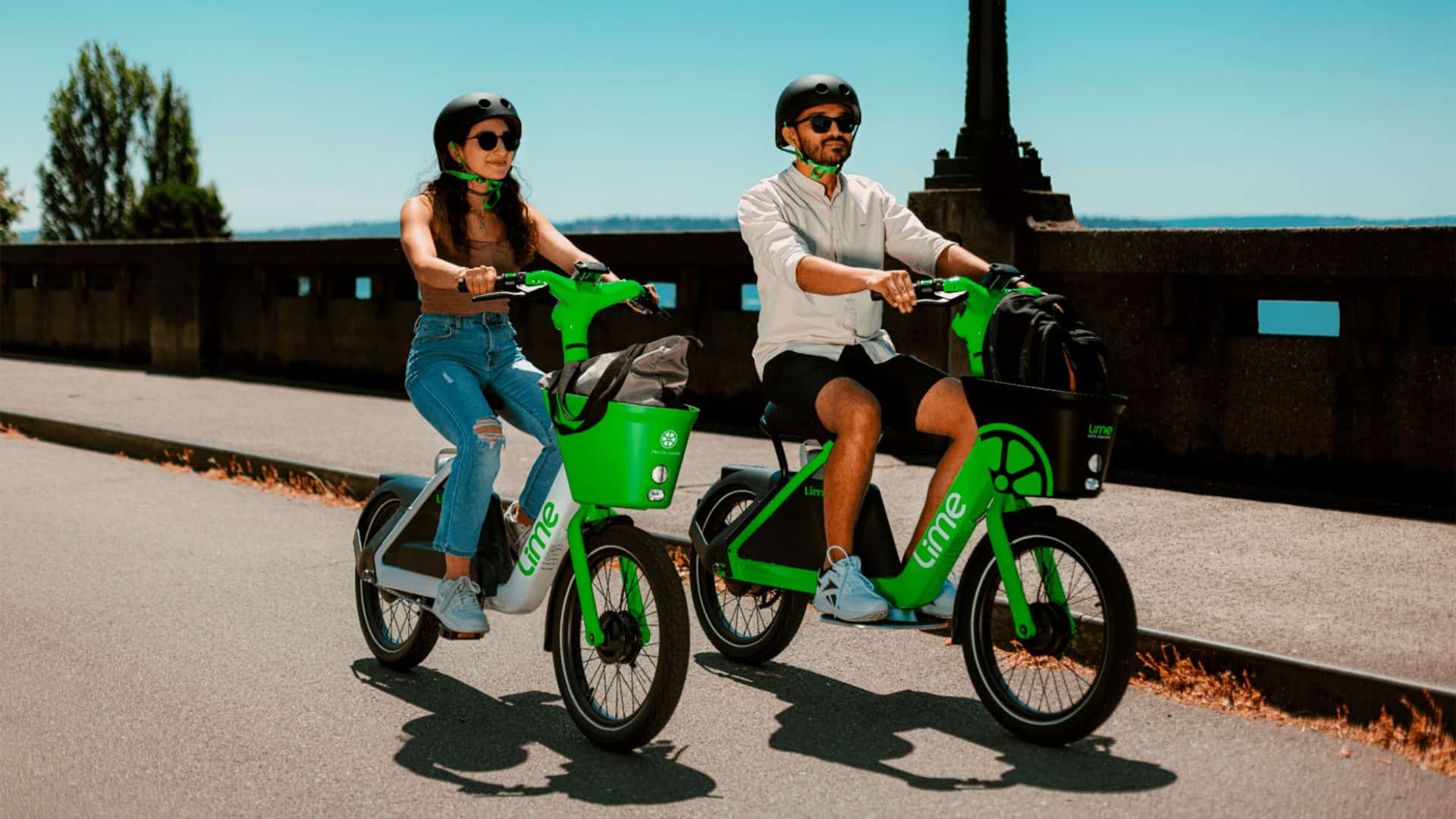 Homem e mulher andando em novas e-bikes da Lime