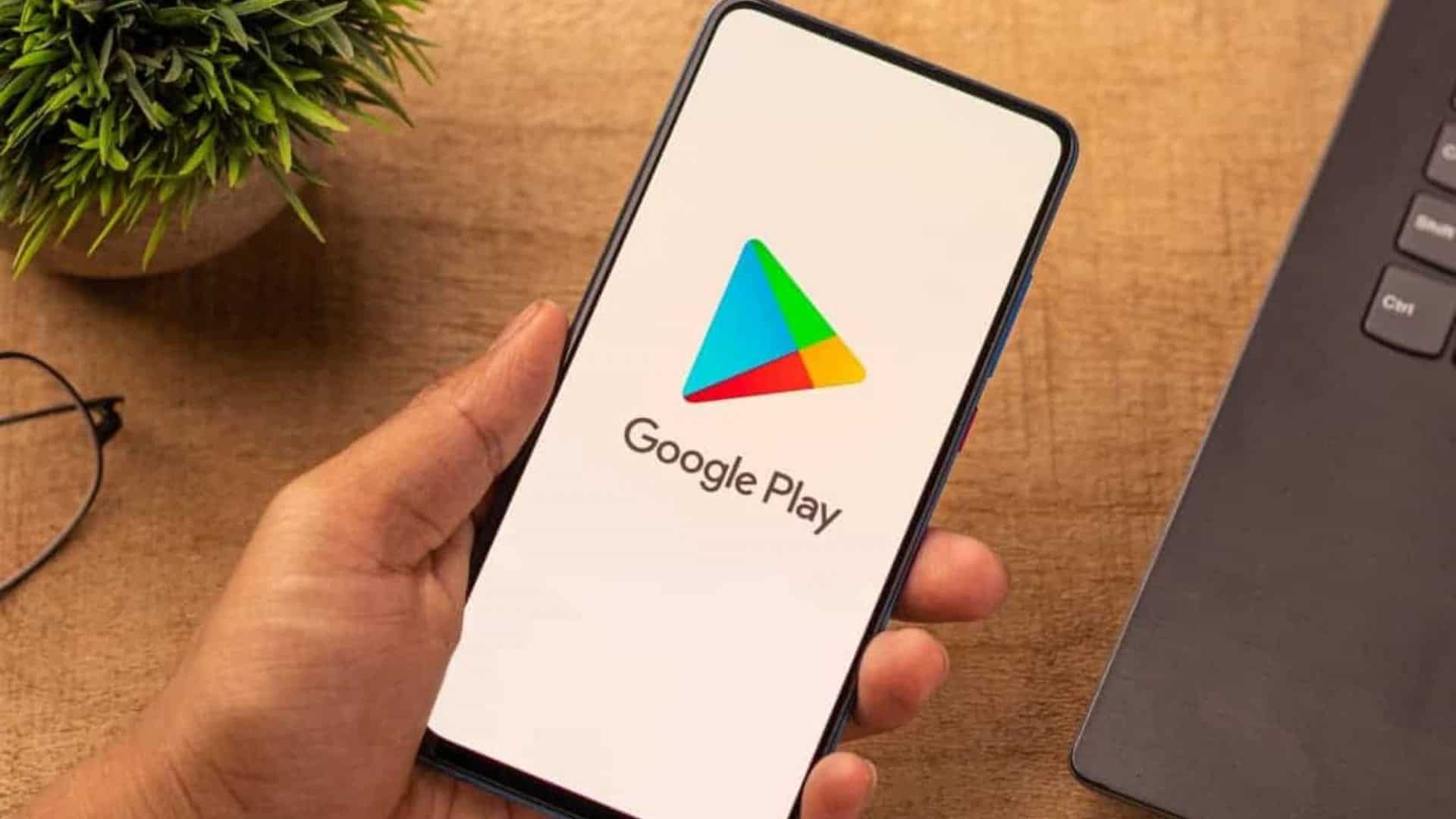 Logo do Google Play em um smartphone segurado por uma mão