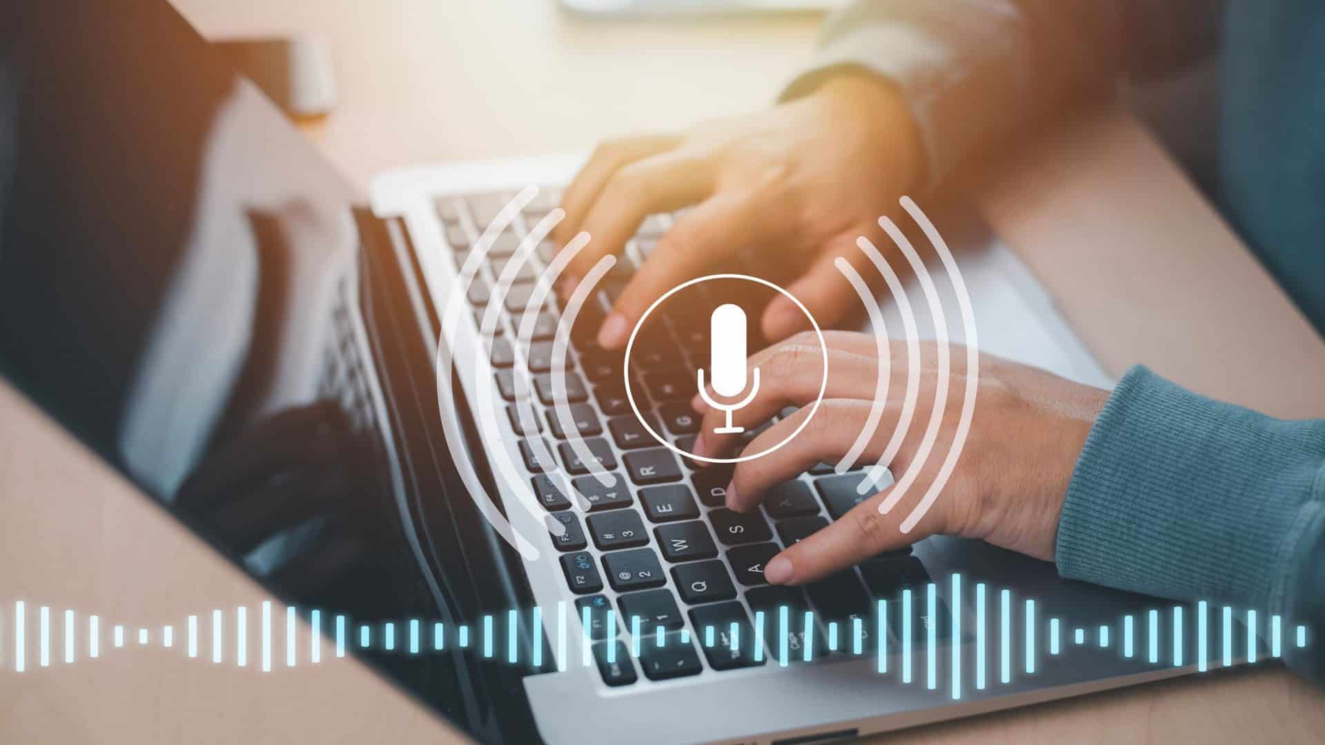 Imagem ilustrativa mostra mãos digitando em laptop e ícone de áudio para falar sobre ferramentas de ia para transcrever áudio