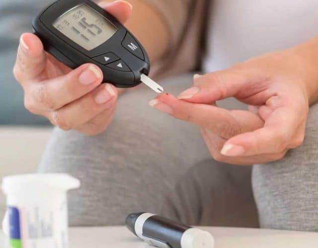Pessoa analisando nível de glicose no sangue em aparelho