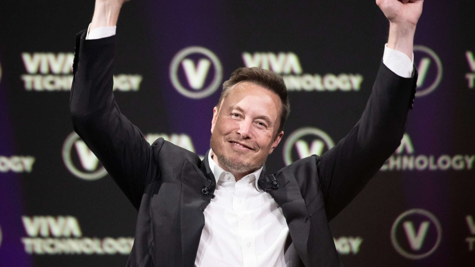 Imagem mostra Elon Musk erguendo os punhos e esboçando um sorriso