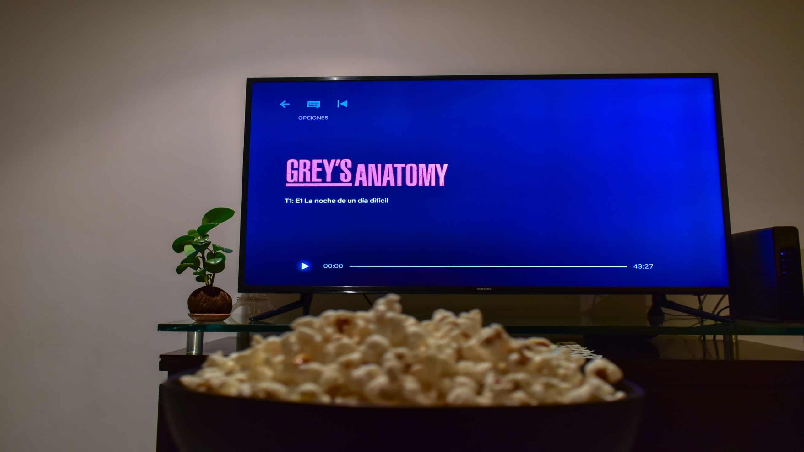 Cali, Colômbia - 26 de agosto de 2019: Aplicativo Netflix na tela da TV reproduzindo a série Grey's Anatomy atrás de uma tigela de pipocas.